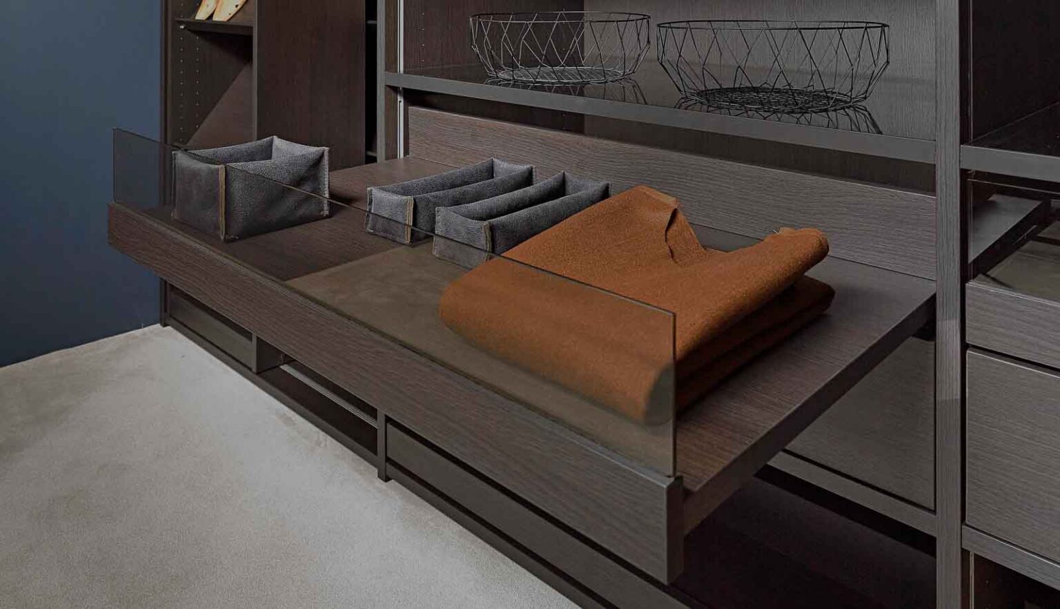 Ankleidezimmer mit Glasfronten – Auszug mit Ablagefächern und gefalteter Kleidung