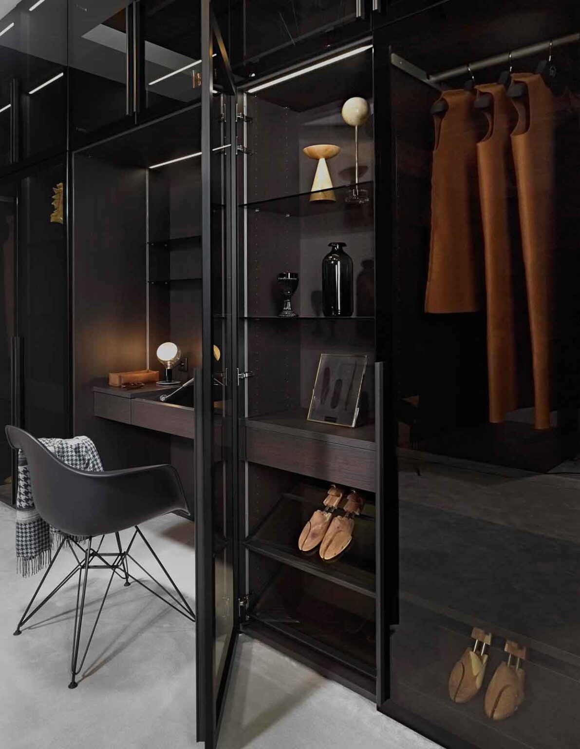 Ankleidezimmer mit Glasfronten – Glastürschrank mit Kleidung und Schuhen neben der Frisiernische