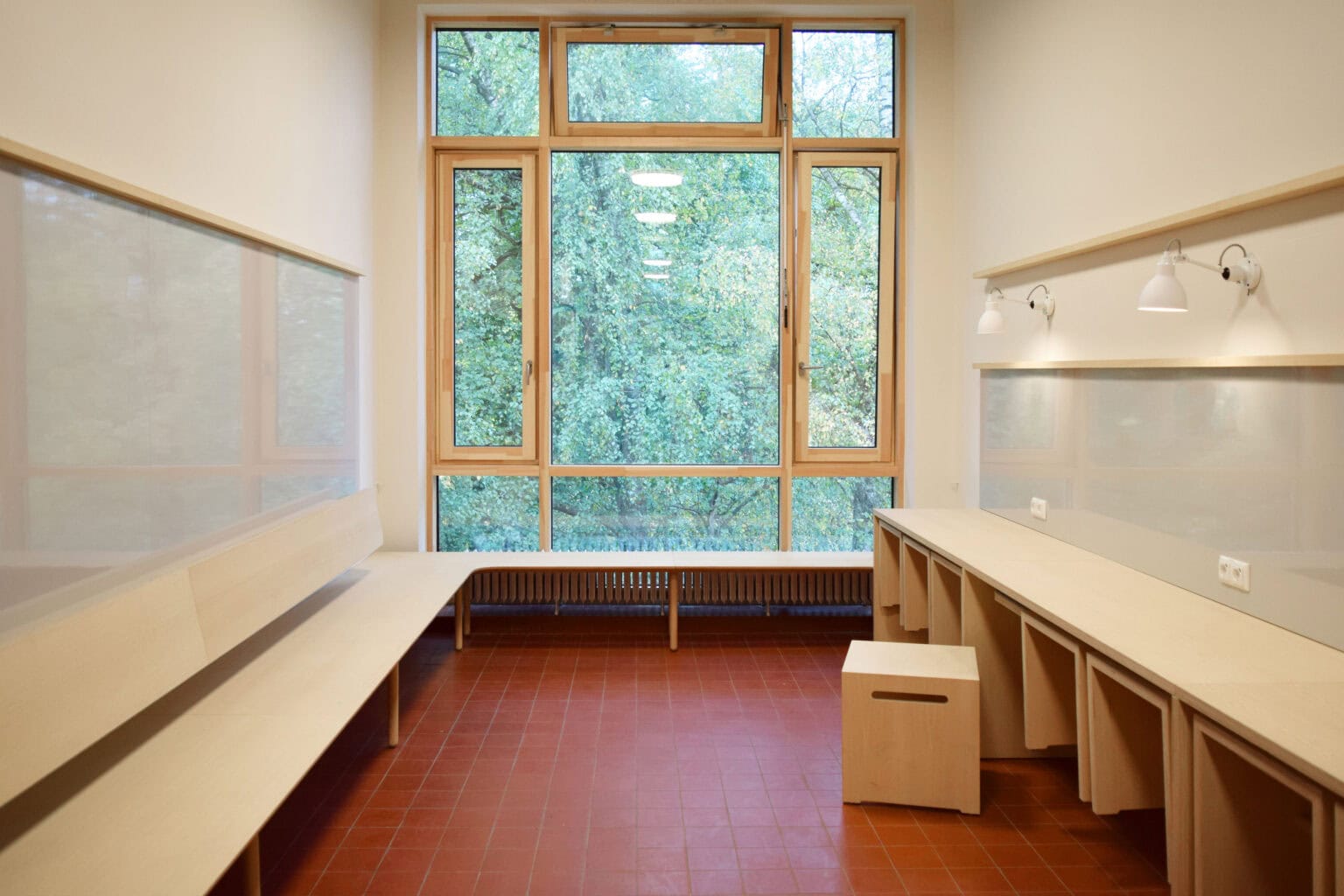 Projekt: Schule am Rondeel – Raum mit umlaufender Sitzbank und Wandtischen am Fenster