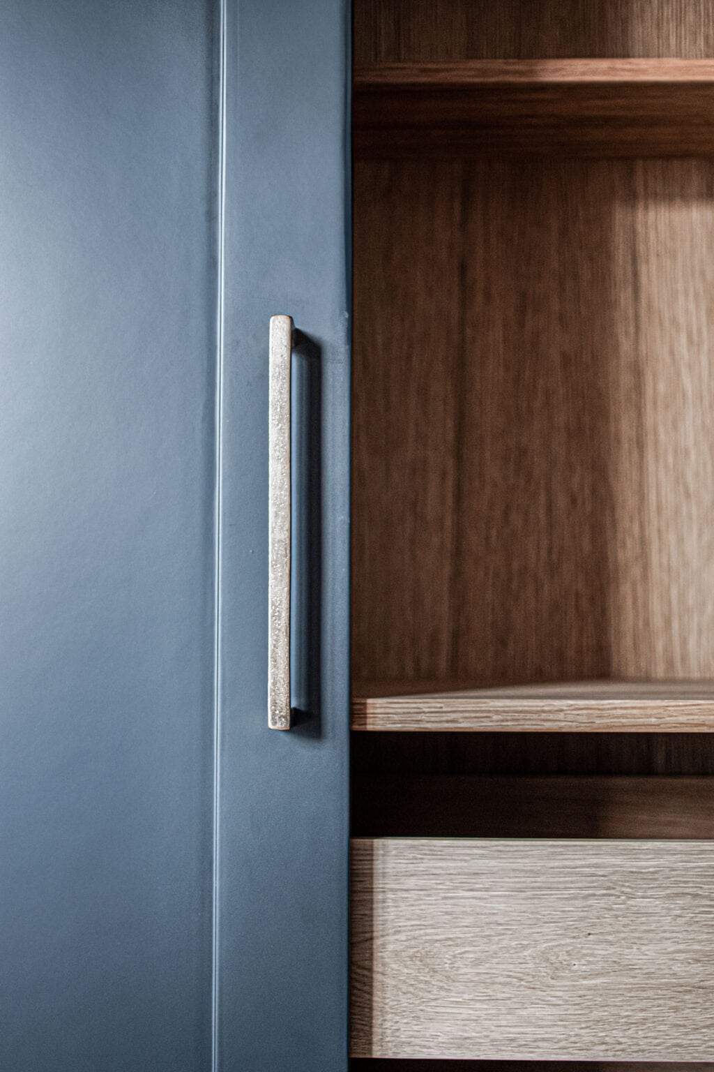 Designküche – Detail: blaue Schranktür mit Holzinnenleben