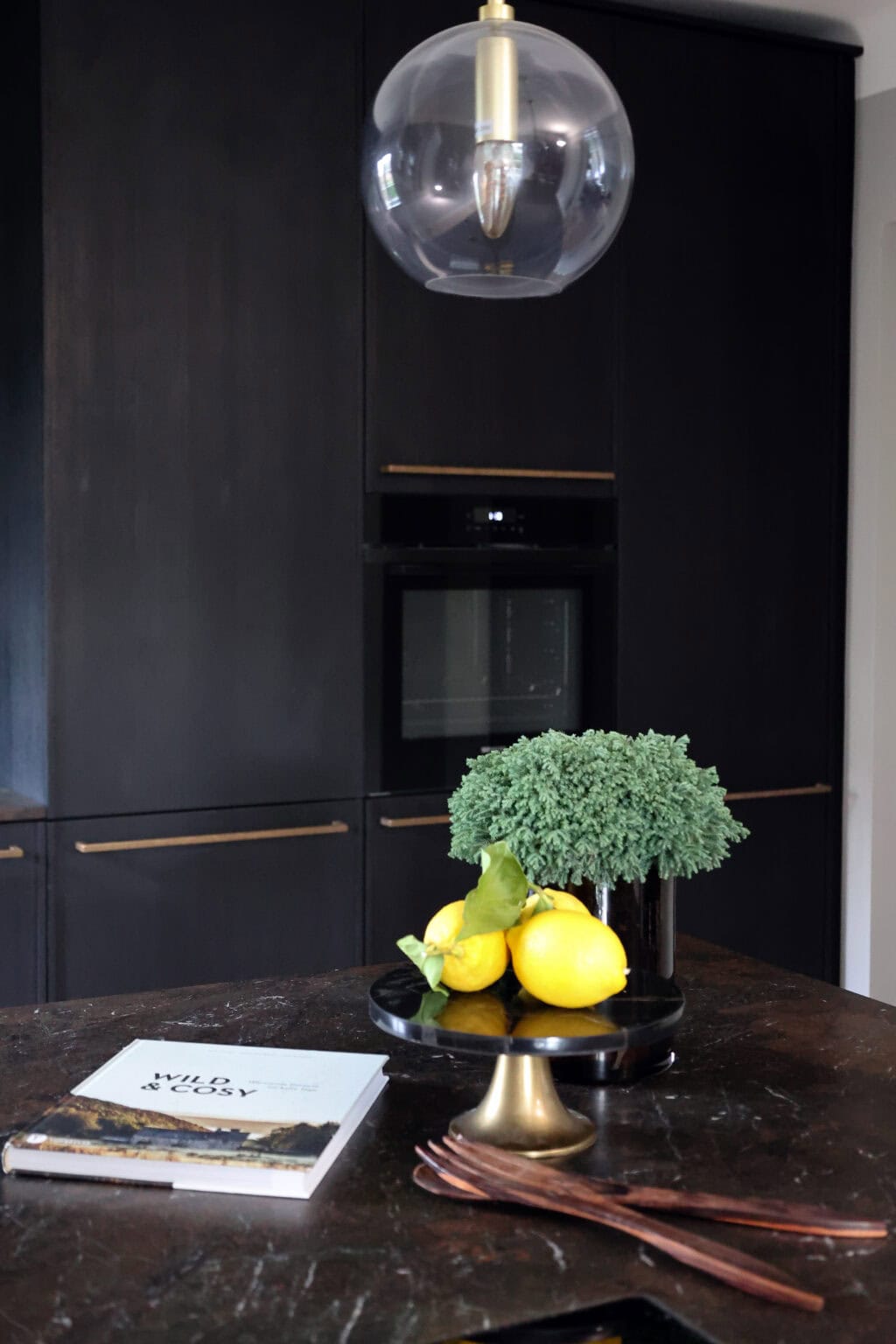 Küche: Black Kitchen – schwarze Hochschränke mit Einbaubackofen hinter der Kochinsel