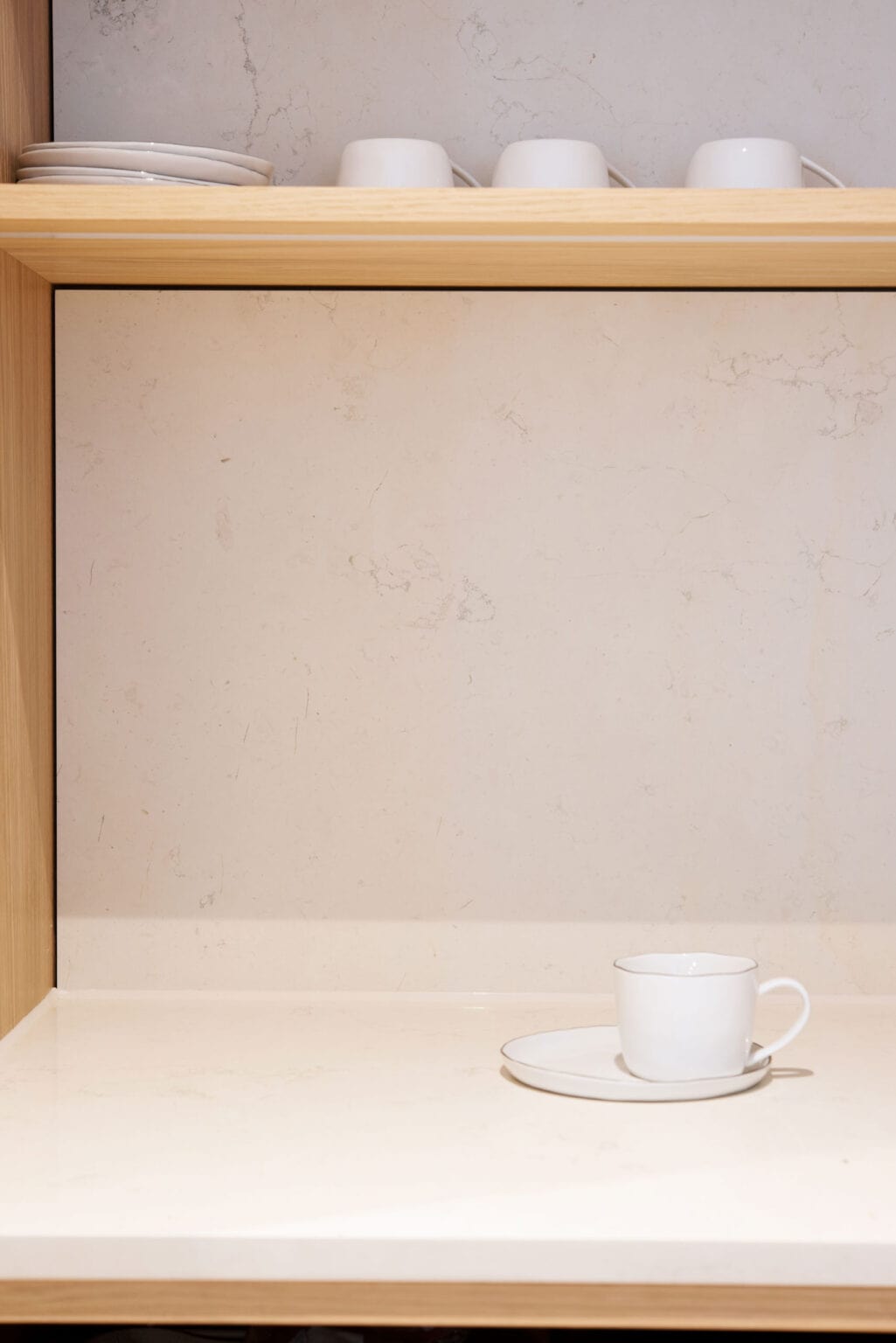 Küche mit Biancone-Marmor – Detail: Nische mit Holzboden und Tasse auf der Marmorplatte