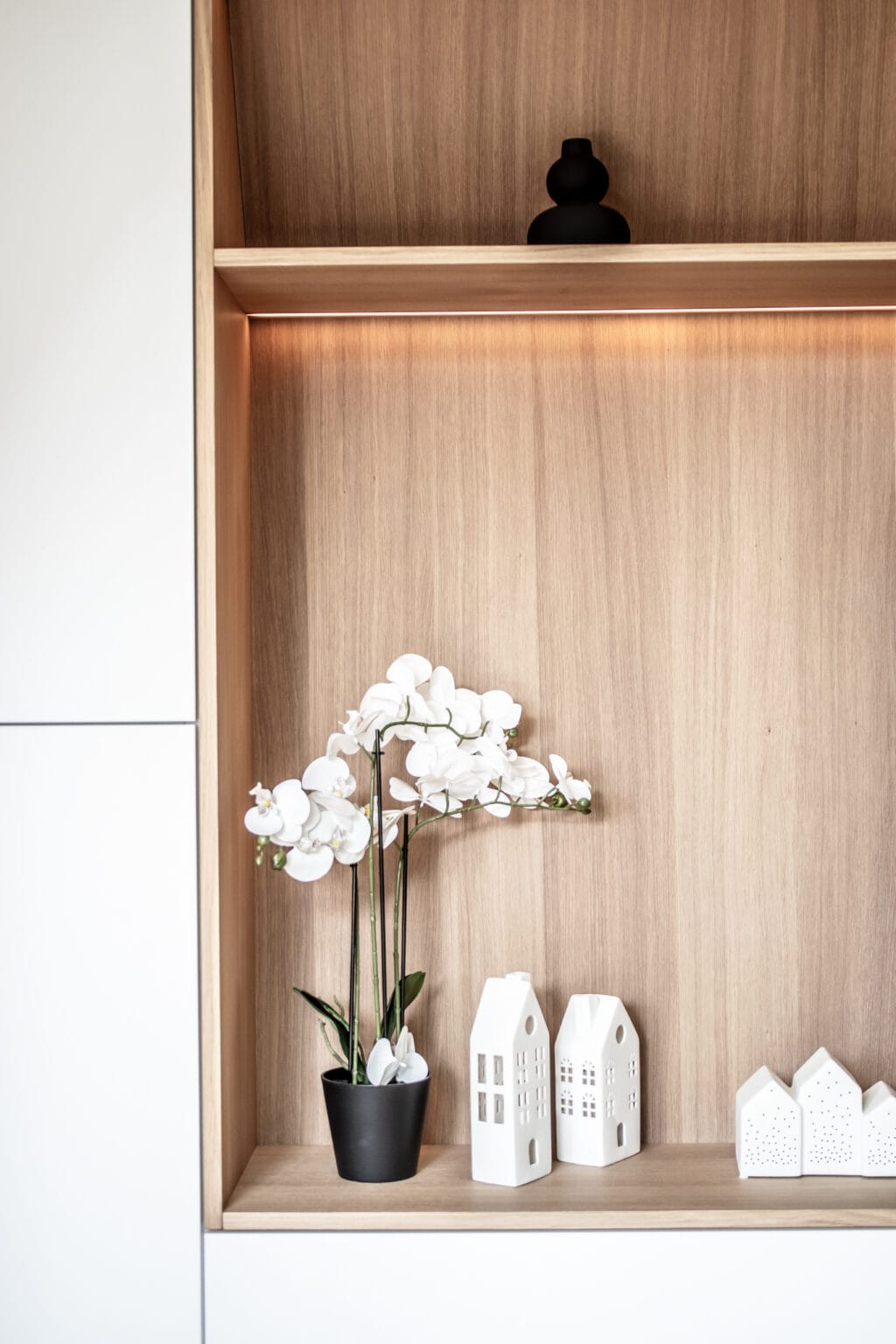 Projekt: Exklusives Wohnen an der Schlei – Detail: beleuchtete Holznische mit Orchidee