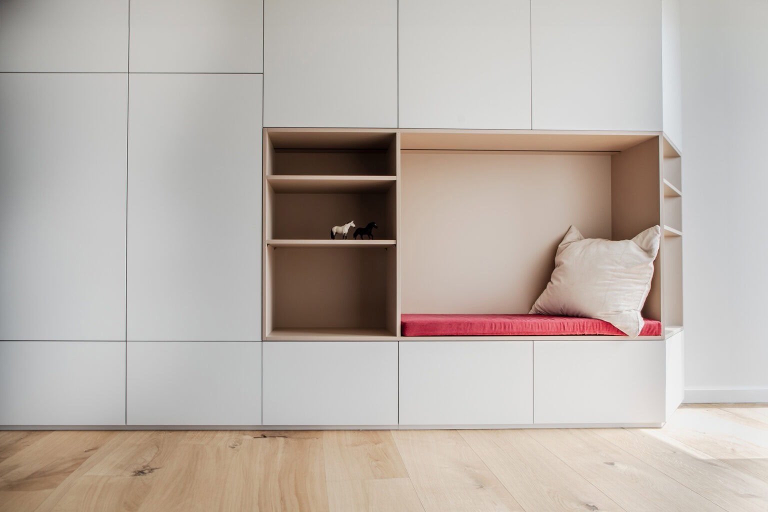 Kinderzimmer für kleine Gäste – Schrankwand mit Sitznische und offenen Regalfächern