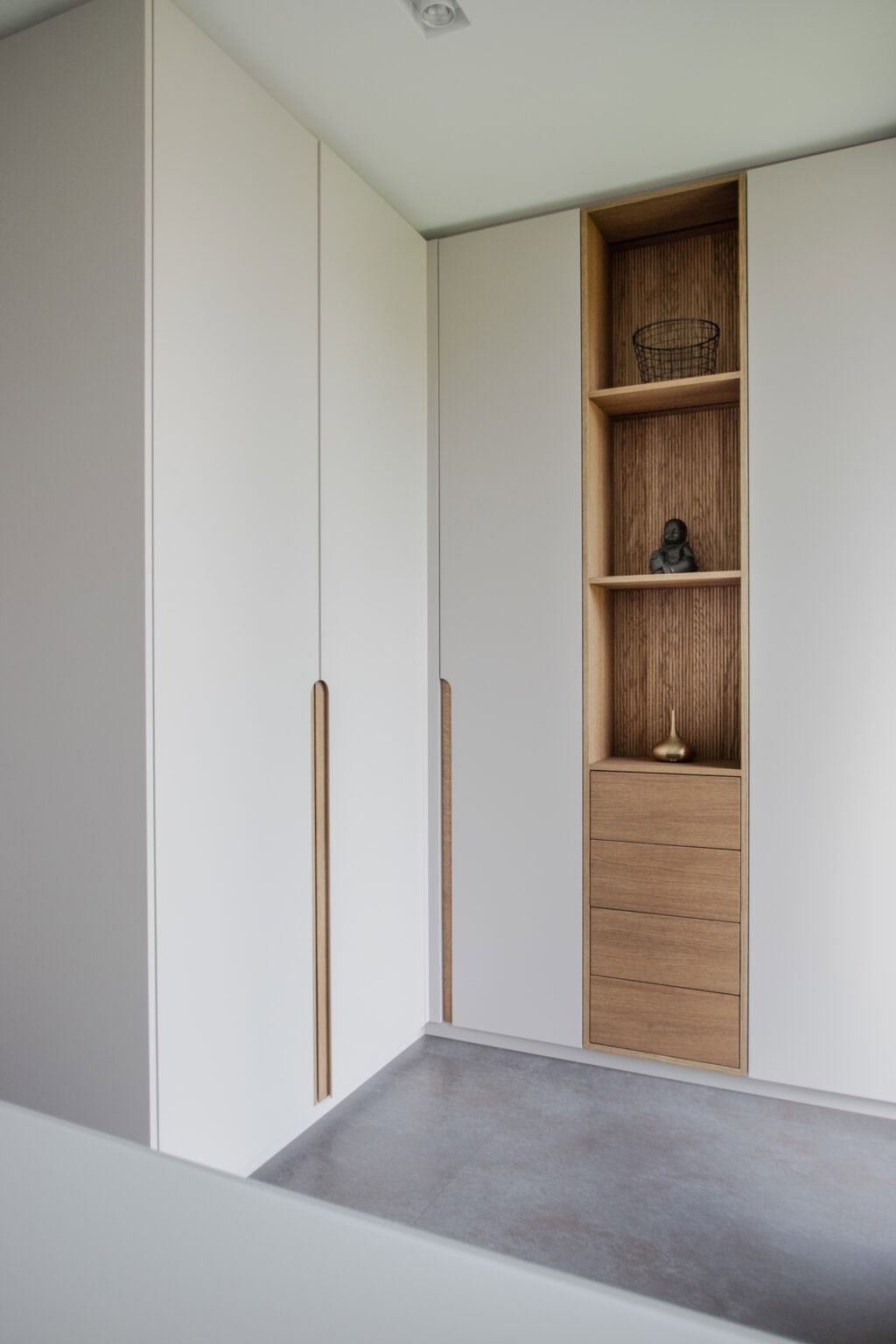 Elegantes Ankleidezimmer – weiße Einbauschränke mit offener Holznische und Schubladen