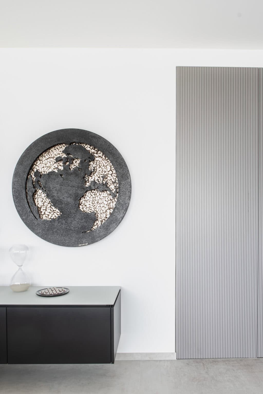 Projekt: Exklusives Wohnen an der Schlei – schwebendes dunkles Lowboard unter rundem Wandbild