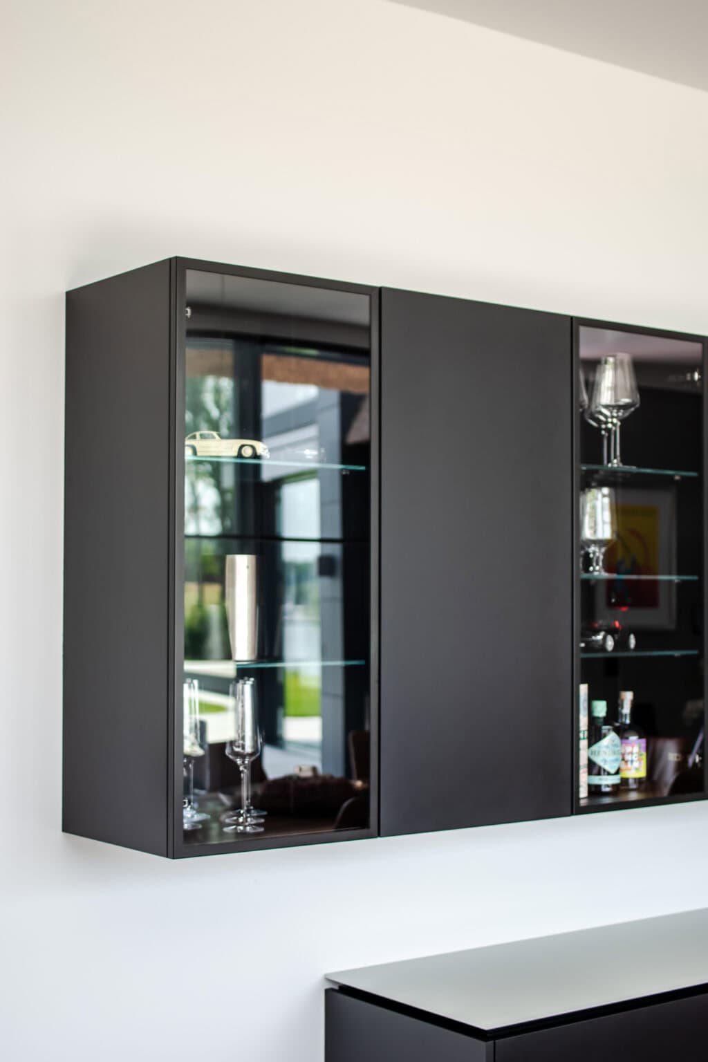 Projekt: Exklusives Wohnen an der Schlei – Detail: dunkler Hängeschrank mit Glastüren