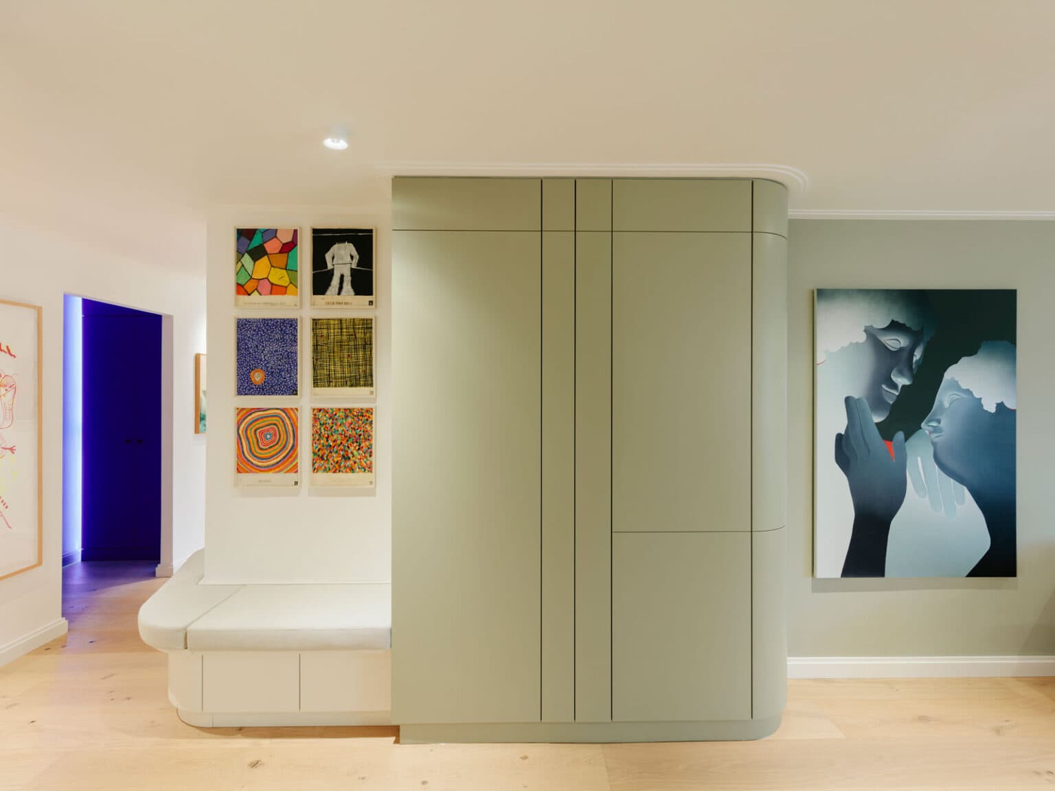 Projekt: Artful Living – salbeigrüner Garderobenschrank neben Sitzbank und Bilderwand