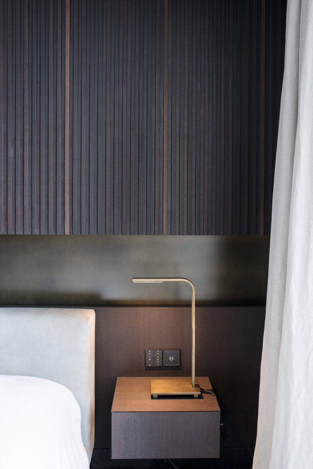 Projekt: Eleganz in Wenge – Detail: Nachttisch mit Leselampe vor Rillenwand