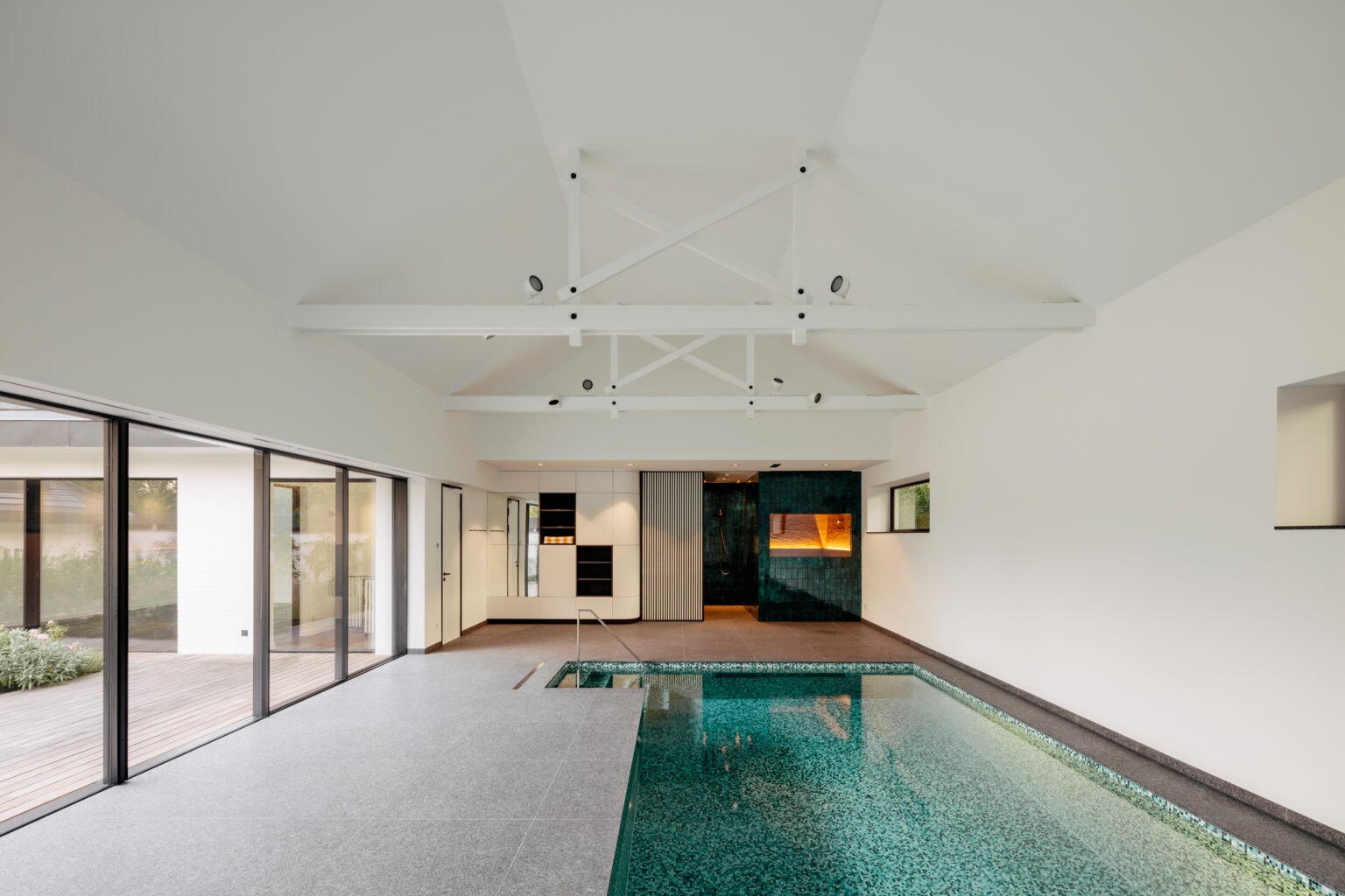 Projekt: Wohnen mit Stil – Schwimmbad mit Einbauschränken und grün gefliester Wand
