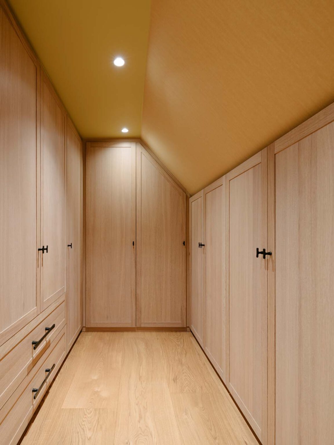 Projekt: Modernes Landhaus – Ankleidezimmer mit Holz-Einbauschränken unter der Dachschräge
