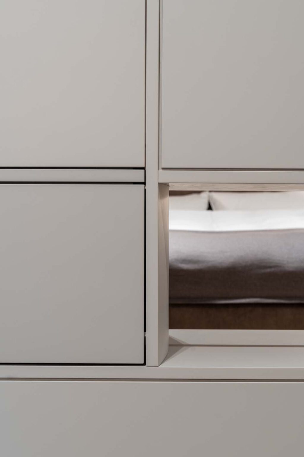 Schlafzimmer: Ein Raum, zwei Perspektiven – Detail: Durchblick durch den Raumteiler-Schrank aufs Bett