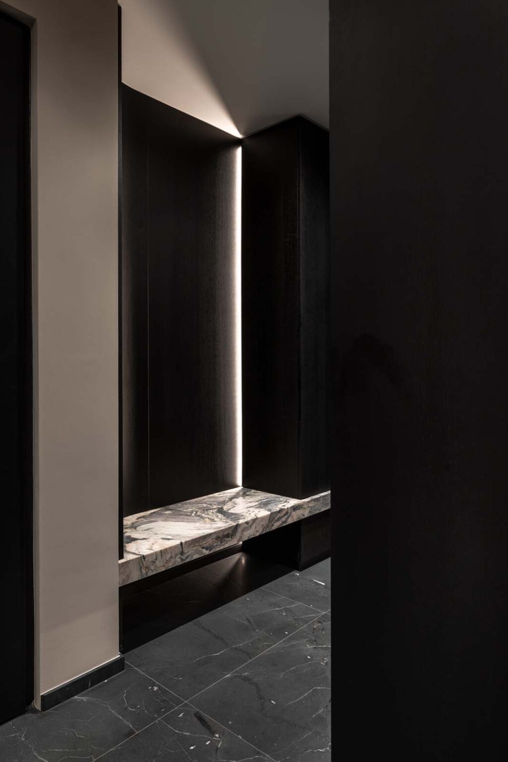 Garderobe: First Impression – dunkle Wandnische mit Steinsitzbank und Lichtleiste