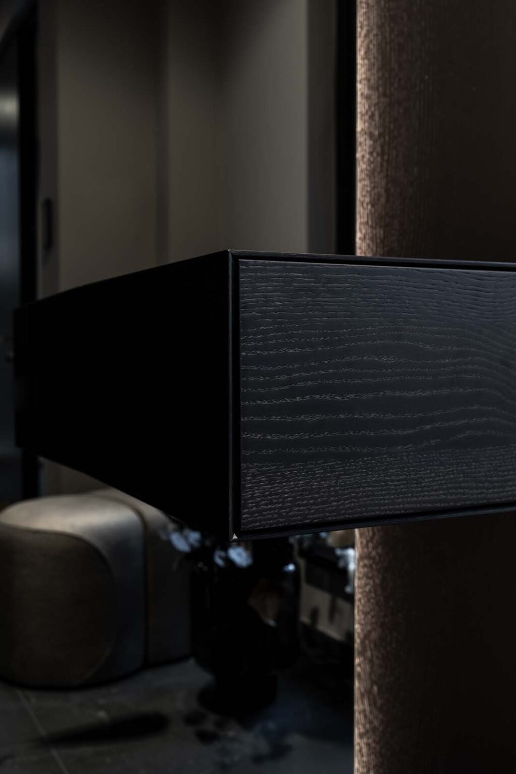 Garderobe: First Impression – Detail: schwebendes Wandboard aus dunklem Holz