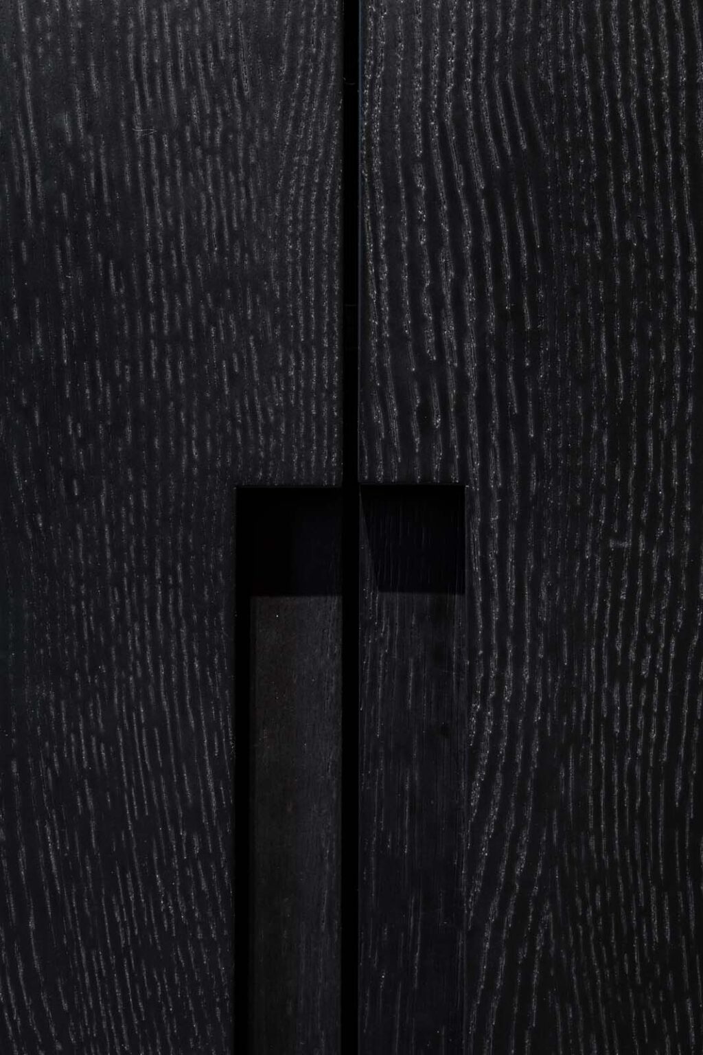 Garderobe: First Impression – Detail: dunkle Holzfronten mit eingelassenem Griff