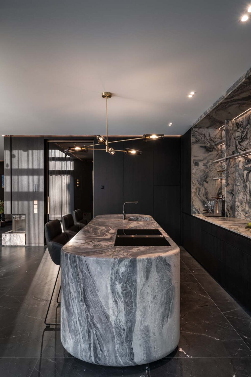Küche: Stone meets Oak – gerundete Kochinsel mit Steinverkleidung in dunkler Küche