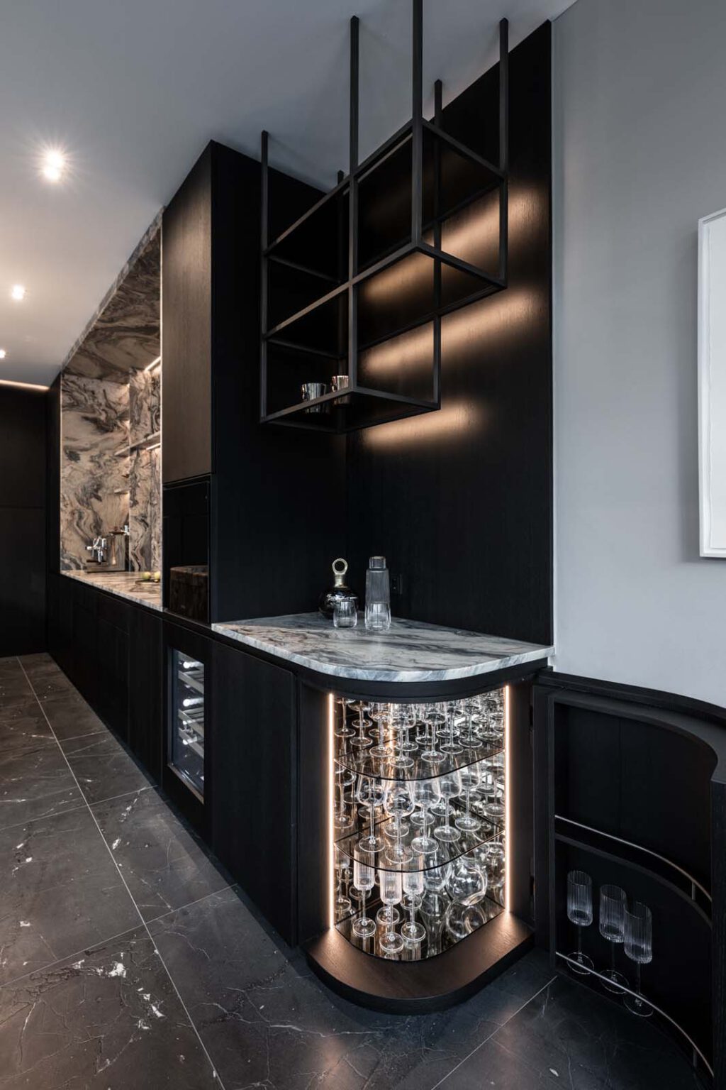 Küche: Stone meets Oak – beleuchtete Glasvitrine unter hängendem Metallregal