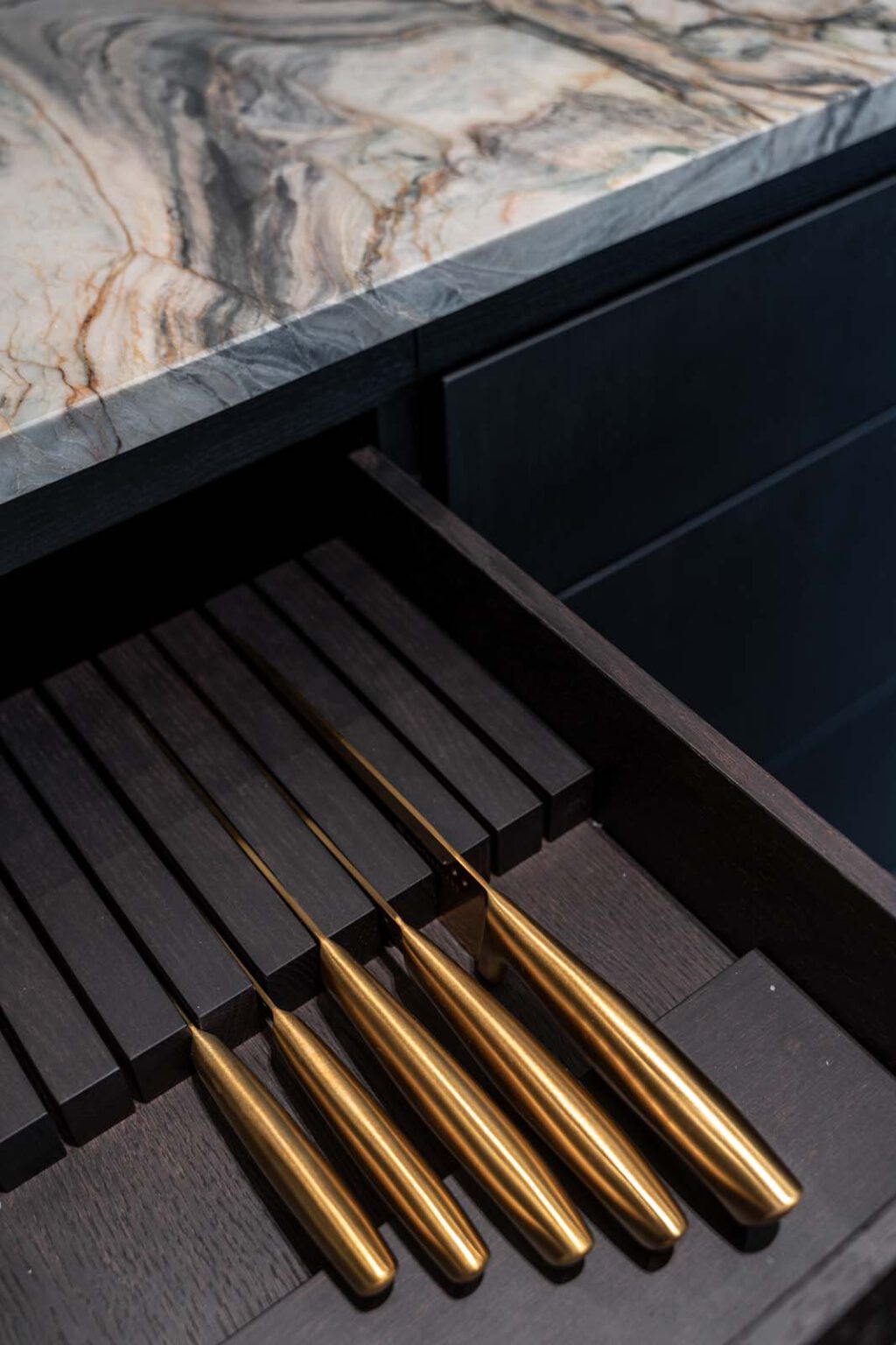 Küche: Stone meets Oak – Detail: Messerauszug mit goldfarbenen Messern